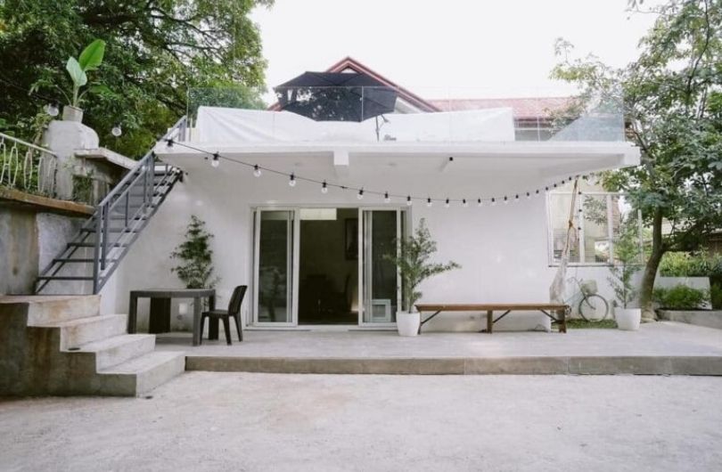 Une femme a transformé un vieux hangar en briques en une petite maison de style minimaliste avec une terrasse sur le toit